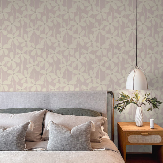 A graphic brushstroke floral wallpaper set against a soft pink background adds subtle boldness with a feminine edge to a modern bedroom.