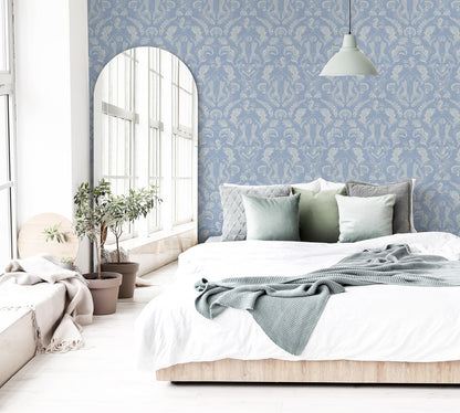 A stunning Dreamy Mermaid wallpaper in a soft coastal blue color palette on a statement wall in a brightly lit bedroom.