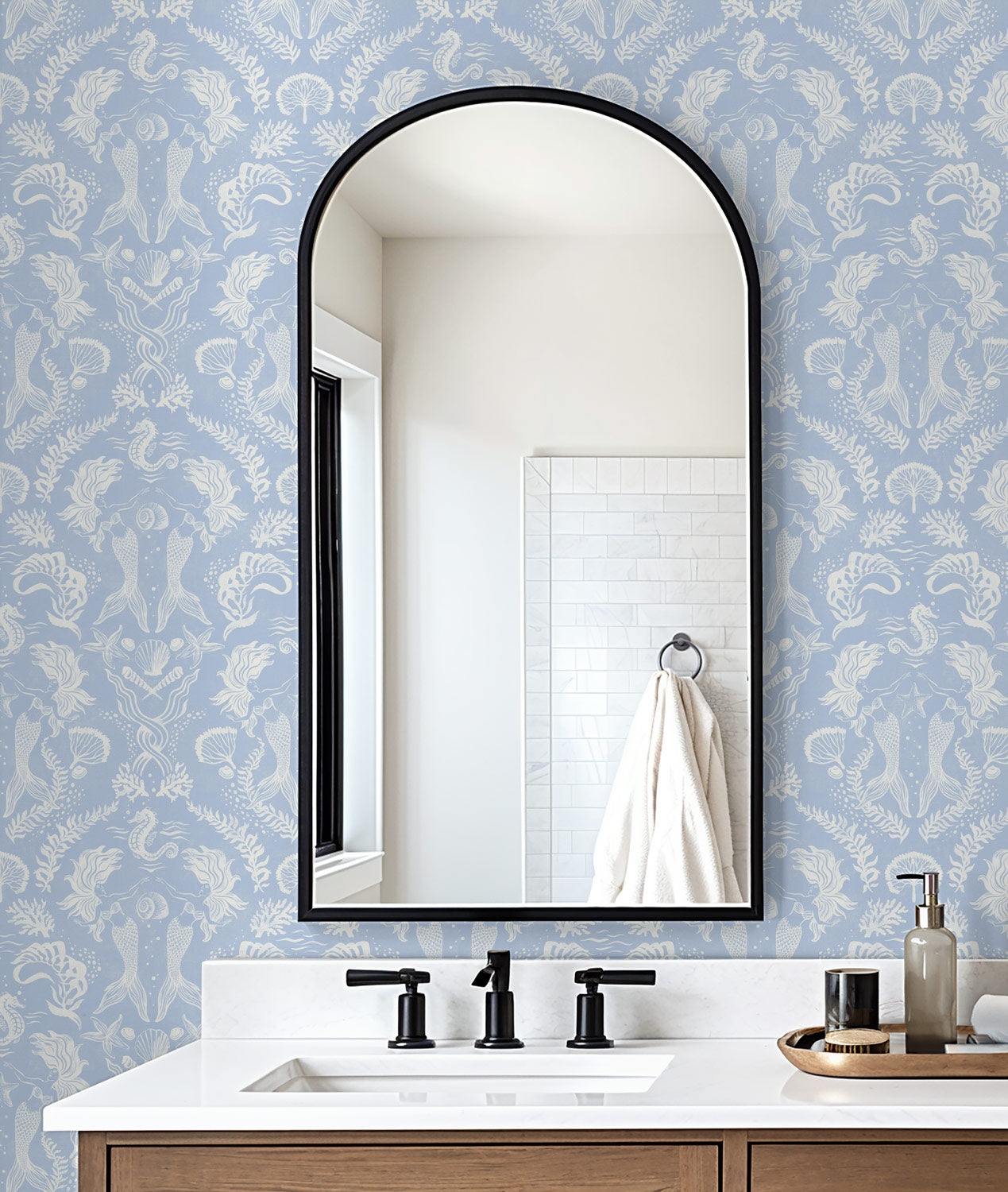 A stunning Dreamy Mermaid wallpaper in a soft coastal blue color palette with seahorses, kelp, coral and shells, in a modern bathroom.