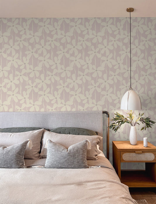 A graphic brushstroke floral wallpaper set against a soft pink background adds subtle boldness with a feminine edge to a modern bedroom.